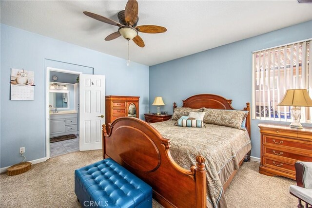 bedroom featuring lofted ceiling, light carpet, connected bathroom, ceiling fan, and baseboards