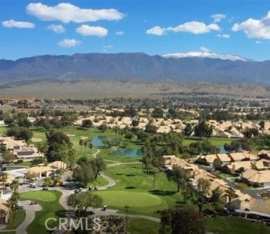 drone / aerial view featuring golf course view and a water and mountain view