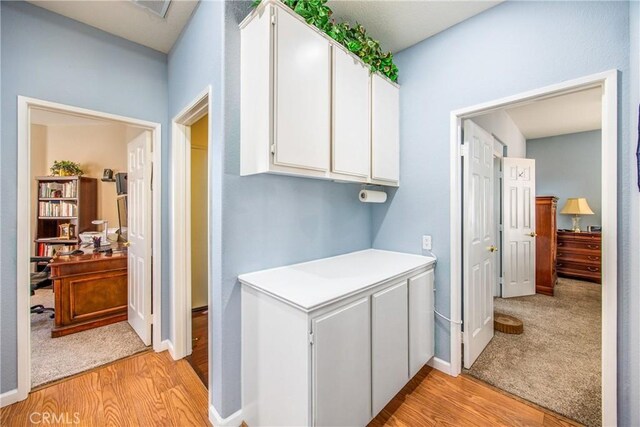 laundry room featuring baseboards and light wood-style floors