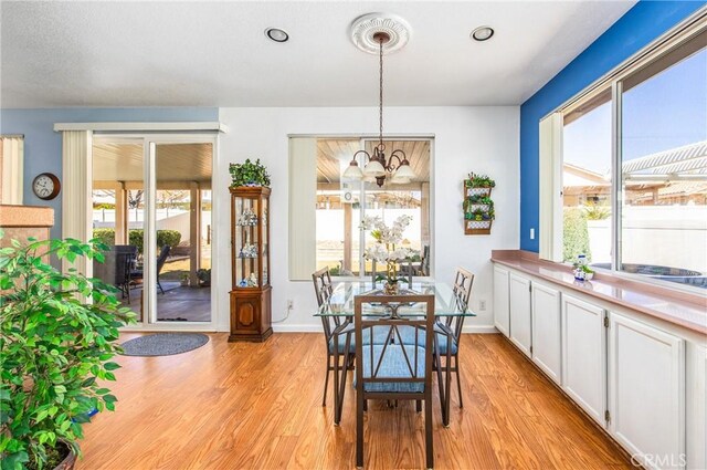 dining area with a chandelier, recessed lighting, baseboards, and light wood-style floors