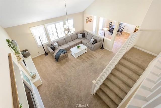 living area featuring a chandelier, lofted ceiling, carpet floors, baseboards, and stairs