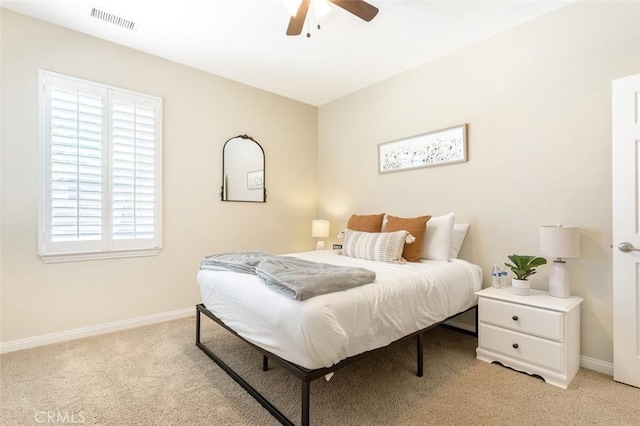 bedroom featuring a ceiling fan, visible vents, light carpet, and baseboards