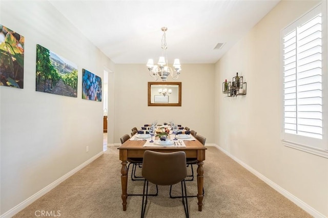 carpeted dining area featuring an inviting chandelier, visible vents, and baseboards