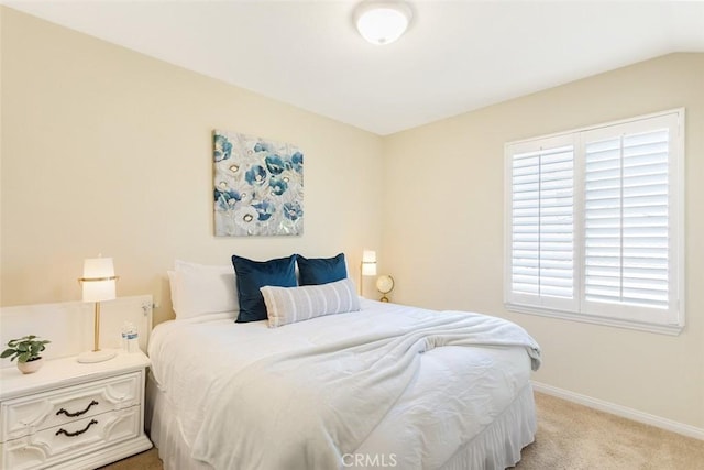 bedroom featuring light colored carpet and baseboards