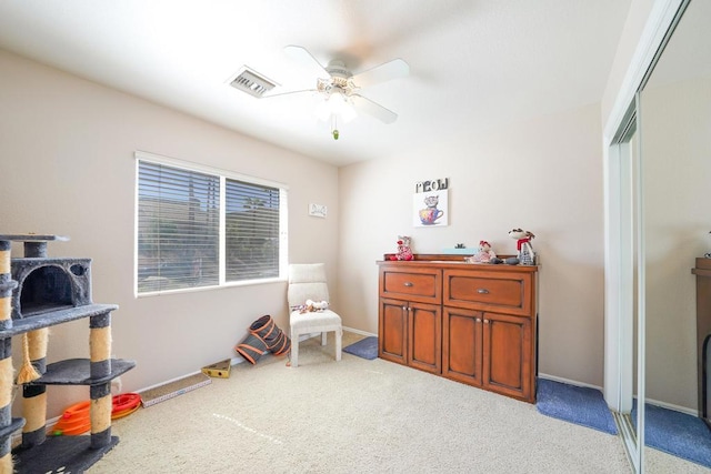 interior space featuring a ceiling fan, baseboards, visible vents, and carpet flooring