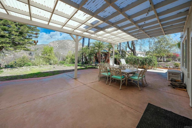 view of patio featuring outdoor dining area, a mountain view, and a pergola