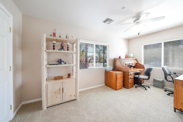 carpeted office space featuring baseboards, visible vents, and ceiling fan