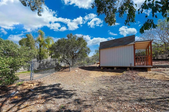 exterior space with an outbuilding, a gate, a fenced backyard, and a shed