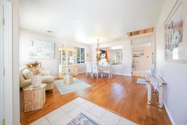 living area with light wood finished floors, baseboards, and visible vents