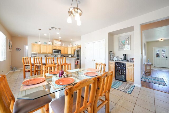 dining room with wine cooler, visible vents, baseboards, and light tile patterned floors