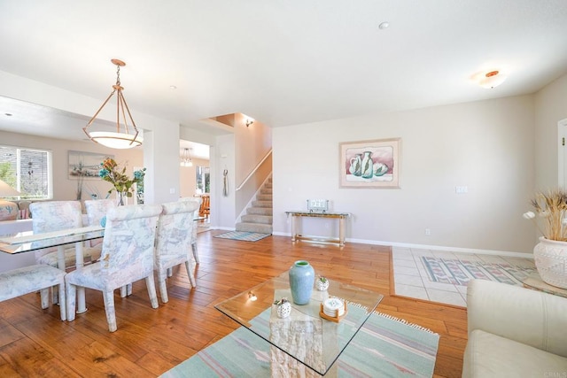 dining room featuring stairs, baseboards, and wood finished floors