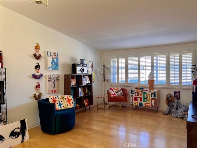 sitting room with light wood finished floors and vaulted ceiling