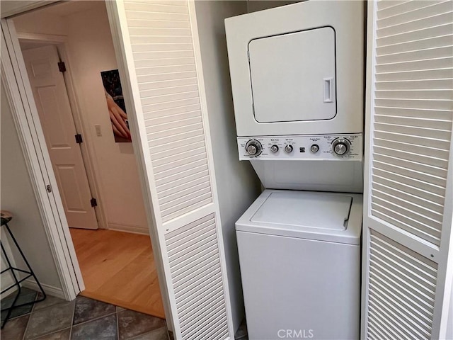 washroom with laundry area, tile patterned flooring, and stacked washer and clothes dryer