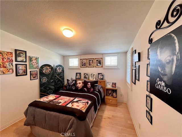 bedroom with a textured ceiling and baseboards