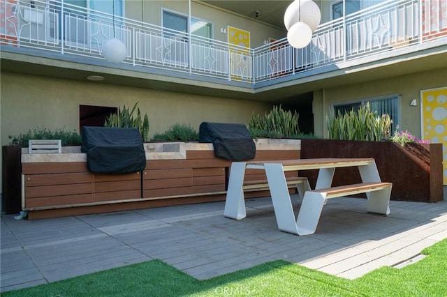 view of patio with grilling area and a balcony