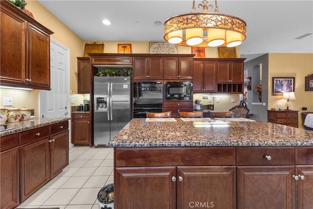kitchen with dark stone countertops, black appliances, light tile patterned flooring, and visible vents