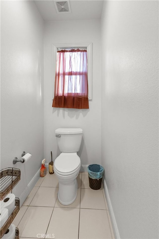 bathroom featuring toilet, tile patterned flooring, visible vents, and baseboards
