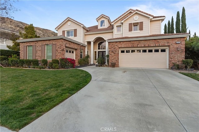 traditional-style house featuring a garage, a front yard, brick siding, and driveway