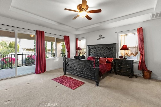 bedroom featuring access to exterior, a raised ceiling, visible vents, carpet flooring, and ceiling fan