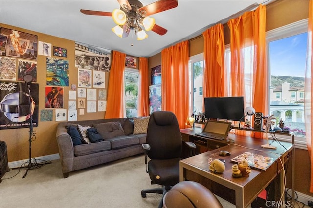 carpeted office with ceiling fan and plenty of natural light