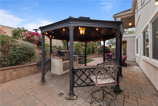 view of patio / terrace featuring a gazebo, exterior kitchen, outdoor dining area, and a grill