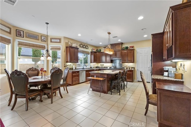 kitchen featuring a breakfast bar, a center island, decorative light fixtures, recessed lighting, and dishwasher