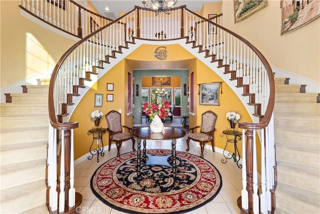 foyer entrance featuring tile patterned flooring, a high ceiling, baseboards, and stairs
