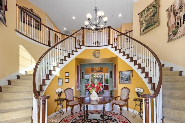 stairs with recessed lighting, a notable chandelier, a towering ceiling, and baseboards