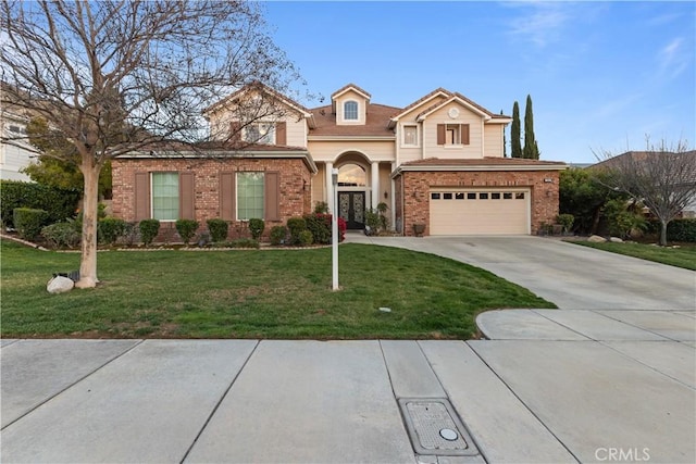 traditional-style house featuring a garage, driveway, a front lawn, and brick siding