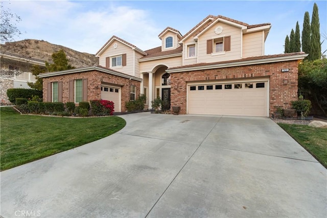 traditional-style house featuring an attached garage, a front lawn, concrete driveway, and brick siding