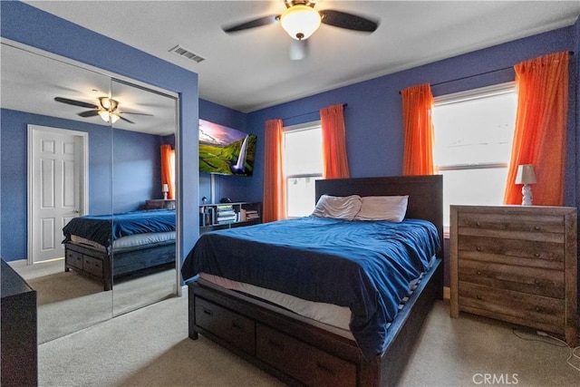 carpeted bedroom with ceiling fan, multiple windows, a closet, and visible vents