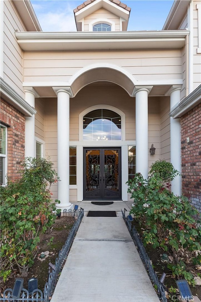 doorway to property featuring french doors and brick siding