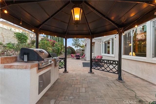 view of patio / terrace with a gazebo, fence, outdoor dining area, and area for grilling