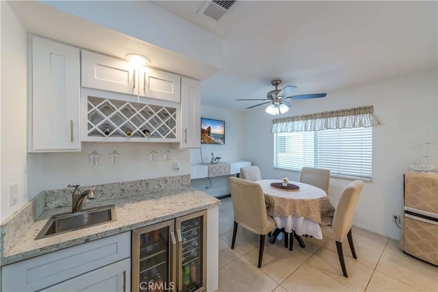 dining room with light tile patterned floors, wine cooler, visible vents, a ceiling fan, and indoor wet bar