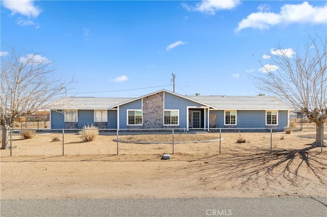 single story home featuring stone siding and a fenced front yard