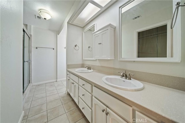 full bathroom with a stall shower, visible vents, a sink, and double vanity