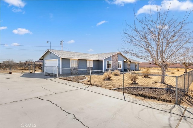 single story home featuring a fenced front yard, concrete driveway, and a garage