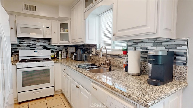 kitchen featuring white appliances, a sink, visible vents, and white cabinets