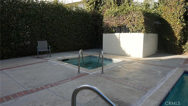 view of swimming pool featuring an in ground hot tub, a patio area, and fence