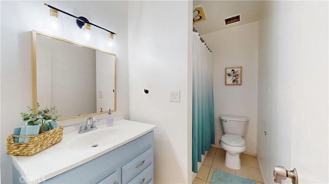 bathroom with toilet, tile patterned flooring, and vanity