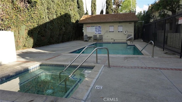 pool with a patio area, fence, and a community hot tub