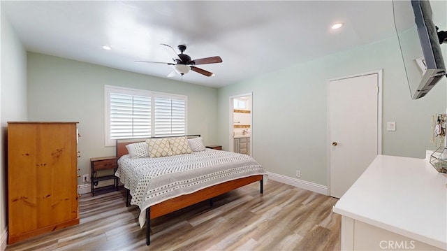 bedroom with baseboards, a ceiling fan, ensuite bath, light wood-style floors, and recessed lighting