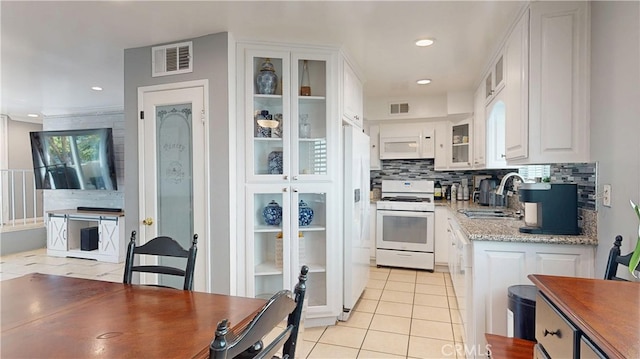 kitchen featuring white appliances, a sink, visible vents, and white cabinets