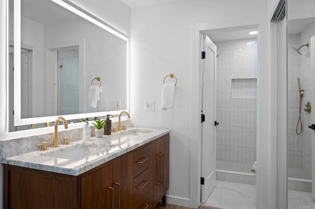 bathroom featuring marble finish floor, a shower stall, and a sink