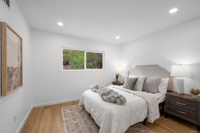 bedroom featuring light wood-style floors, recessed lighting, visible vents, and baseboards