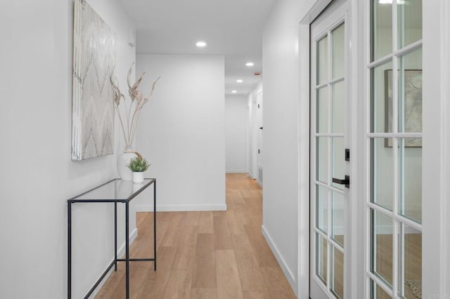 corridor with baseboards, wood finished floors, and recessed lighting