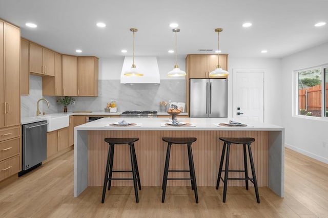 kitchen with visible vents, decorative backsplash, appliances with stainless steel finishes, custom exhaust hood, and a sink