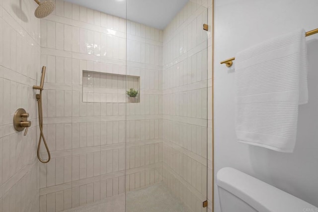 bathroom with toilet and tiled shower