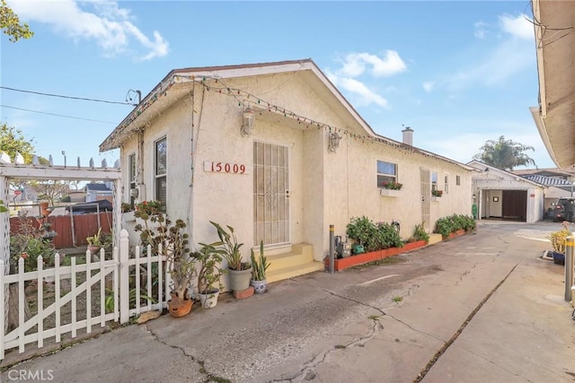 view of property exterior with fence and stucco siding