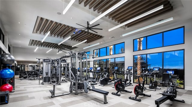 workout area with carpet floors and a towering ceiling